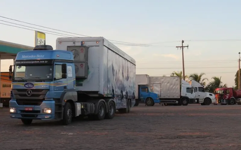 Caminhões estacionados em posto de combustível à beira da rodovia